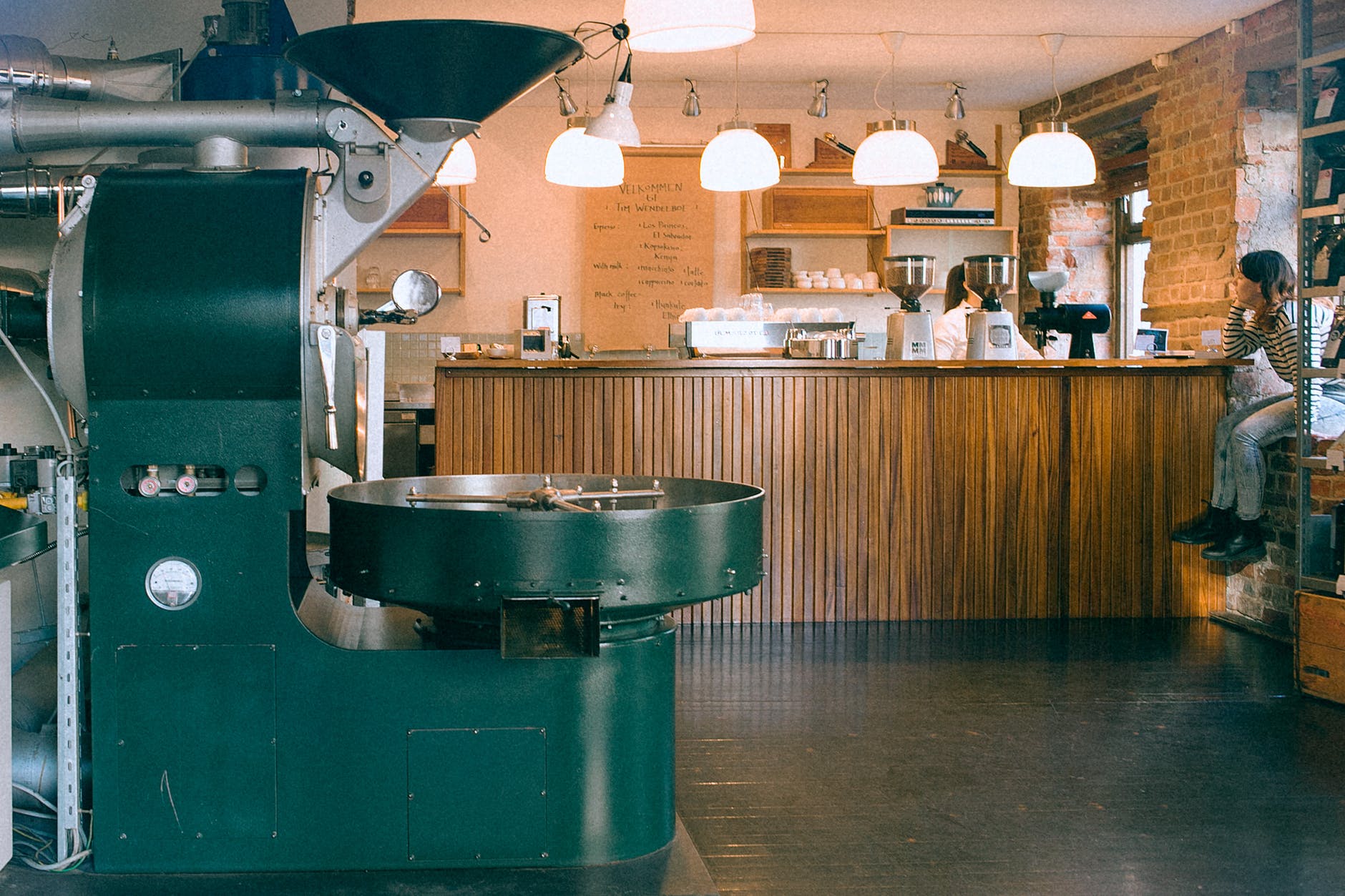 coffee roasting machine in cafe with anonymous barista and girlfriend